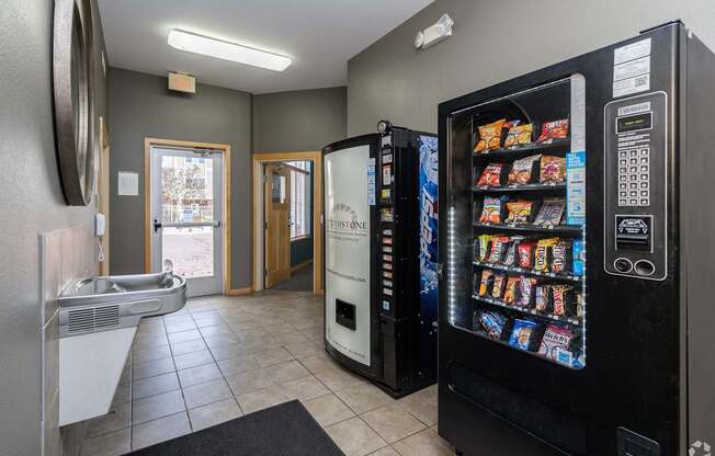A vending machine sits in a room with a doorway leading to a balcony.