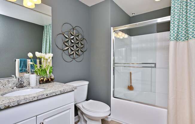A bathroom with a toilet, sink, and shower at The Kitt at Warner Center Apartments, California, 91303