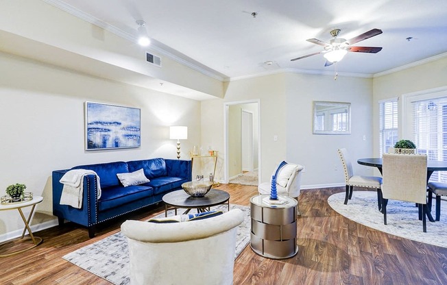 a living room with a blue couch and a ceiling fan