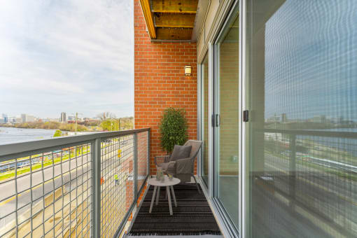 a balcony with a small table and two chairs at The Waterford At Rocketts Landing Apartments, PRG Real Estate, Richmond, Virginia