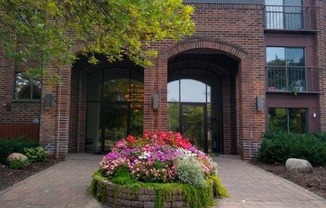 a large brick building with a flower garden in front of it