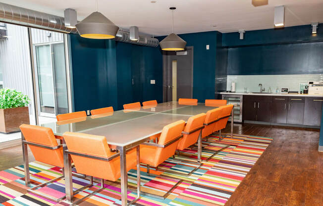 a conference room with a long table and orange chairs