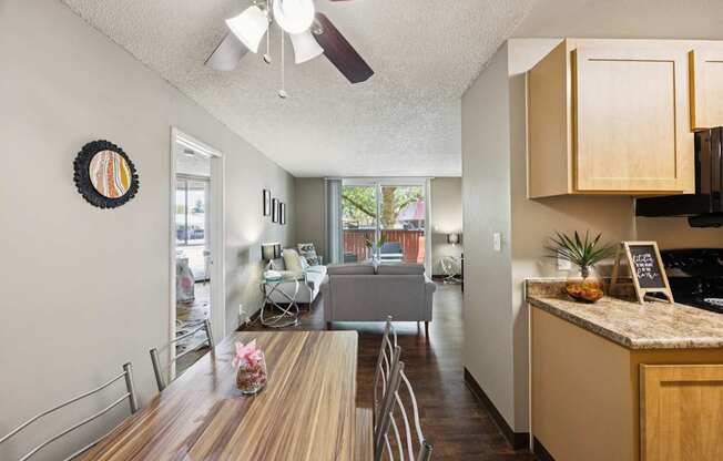 A kitchen with a table and chairs in the foreground and a dining area in the background.