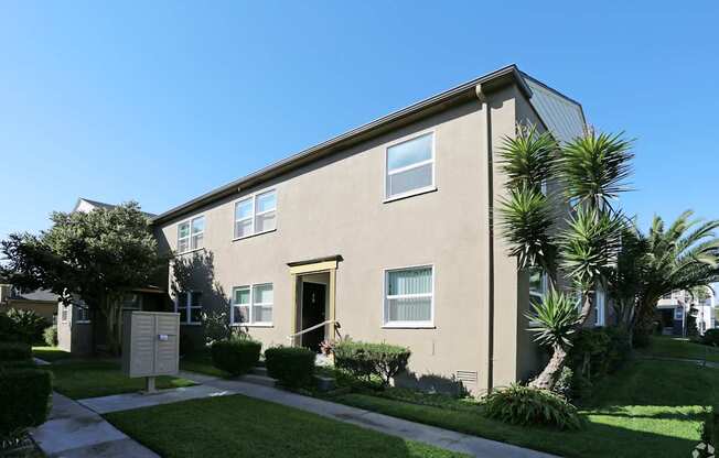 A beige building with a brown door and windows.