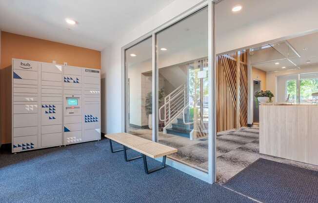 A hallway with a bench and a glass wall leading to another room.