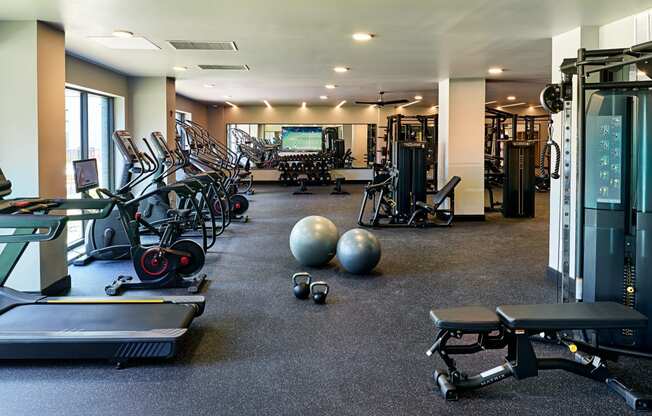 a gym with weights and other exercise equipment and a tv on the wall at Dey & Bergen, Harrison