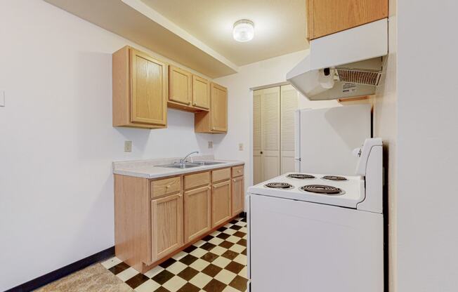 a kitchen with white appliances and a checkered floor