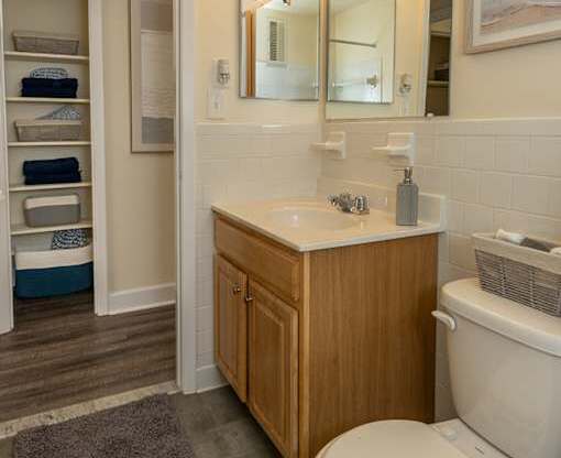 A bathroom with a toilet, sink, and a chandelier.