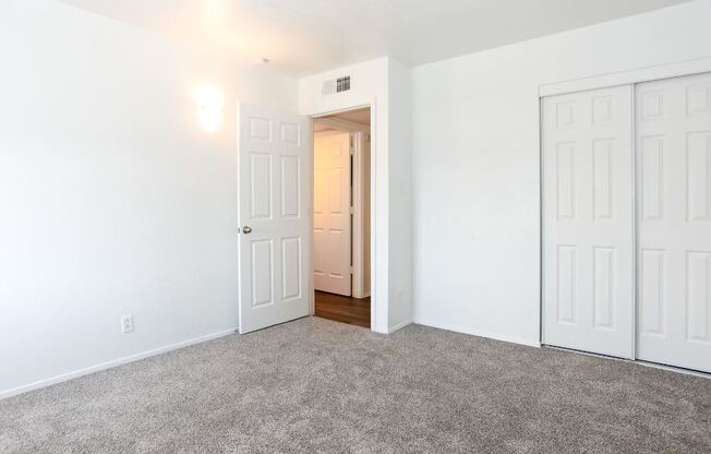 a bedroom with a carpeted floor and white doors