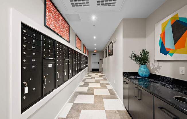 A hallway with a series of lockers on the left and a plant on the counter.