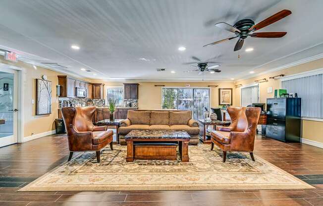 A living room with a brown sofa, two chairs, and a coffee table.