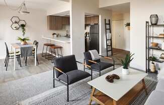 a living room with a dining area and a kitchen in the background