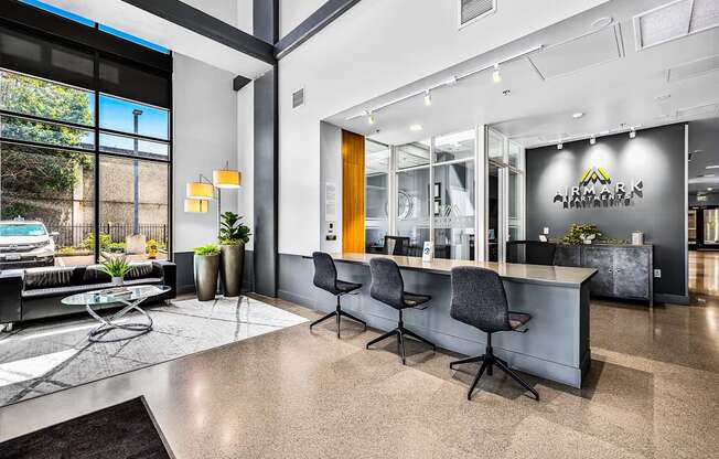 A modern office lobby with a reception desk and chairs.