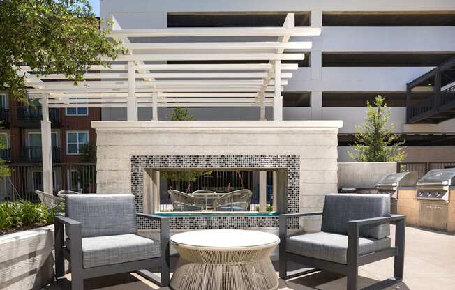 a patio with chairs and a table and a fireplace