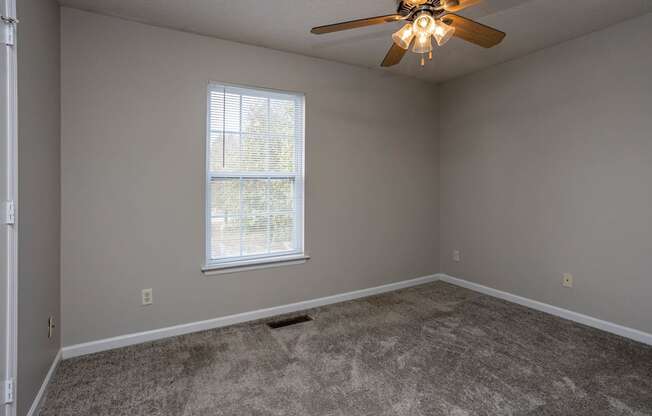 a bedroom with a ceiling fan and a window