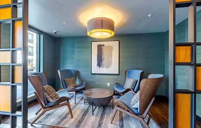 A living room with blue chairs and a wooden table.