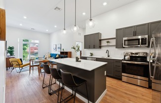 a kitchen with a large island and a dining room with a table and chairs