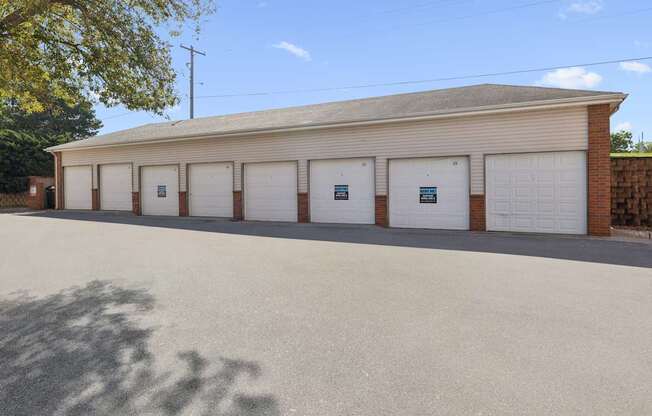 A building with a grey roof and white garage doors.