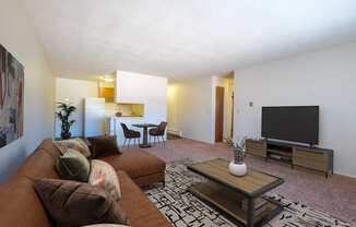 a living room with a couch and a television. Fargo, ND North Manor Apartments