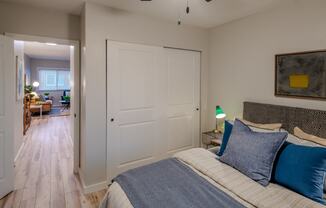 a bedroom with a bed and a door to a living room