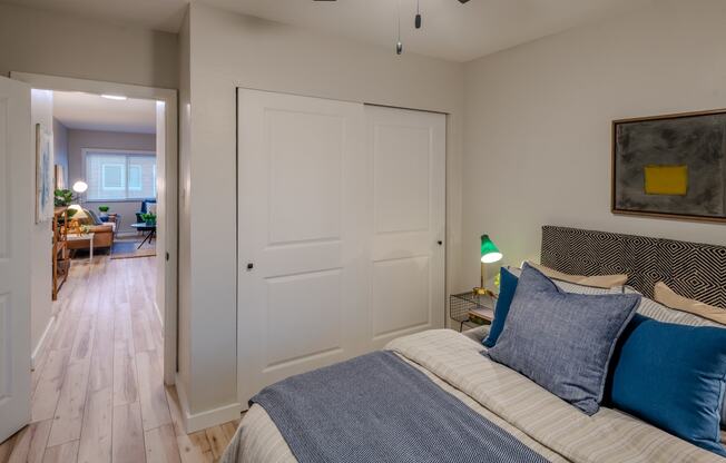 a bedroom with a bed and a door to a living room