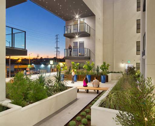 A modern courtyard with a bench and plants.