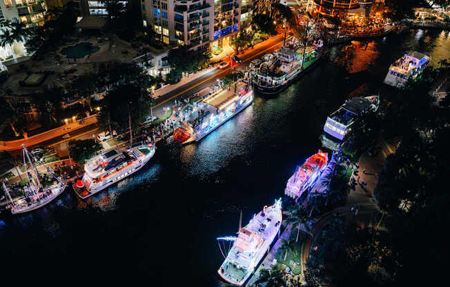 A nighttime view of a city with boats docked in the water.