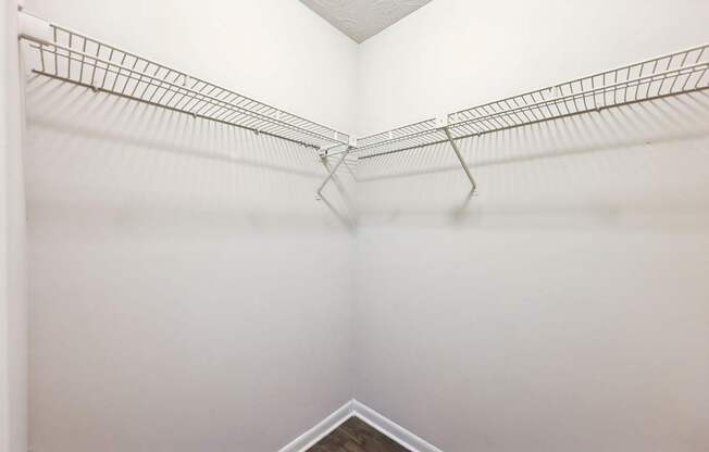 A closets with shelves and clothes rods at Gwinnett Square Apartments in Duluth, GA