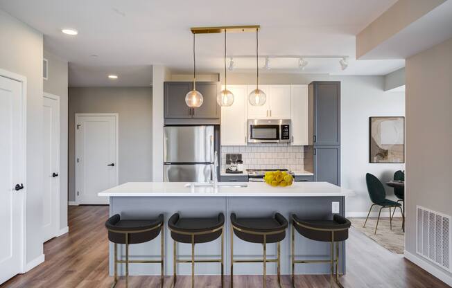 a kitchen with a large center island with four stools