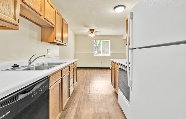 A kitchen with wooden cabinets and a black dishwasher.