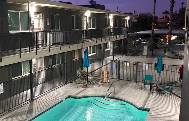 A swimming pool on a balcony with a person standing on the right side.