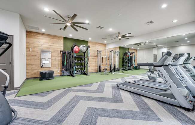 a gym with treadmills and other exercise equipment at the enclave at woodbridge apartments in
