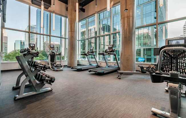 A gym with treadmills, weights, and exercise equipment.