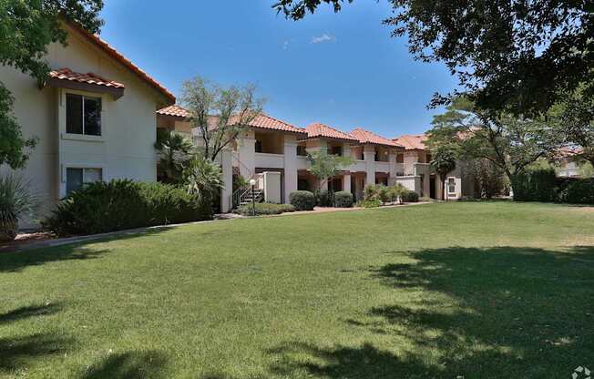 A row of houses with green lawns in front.
