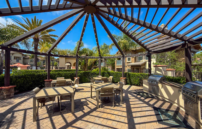 A patio with a table and chairs under a roof.