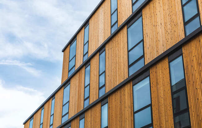 A building with wooden panels and black trimmed windows.