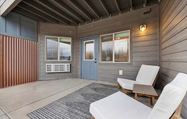 A cozy outdoor seating area with a couch, chair, and a table.