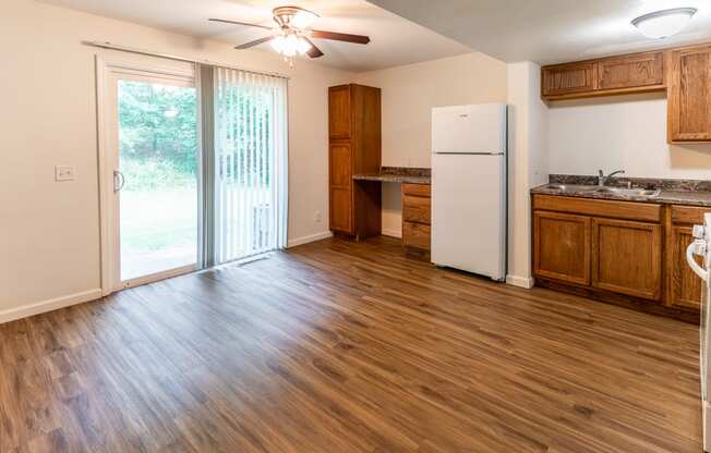 an empty kitchen with a refrigerator and a sliding glass door