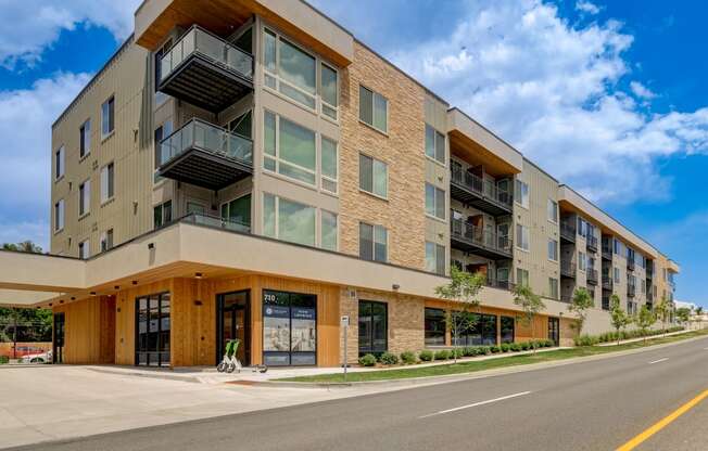 an apartment building with a street in front of it and a blue sky in the background