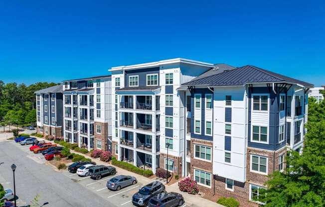 an aerial view of an apartment building with cars parked in a parking lot