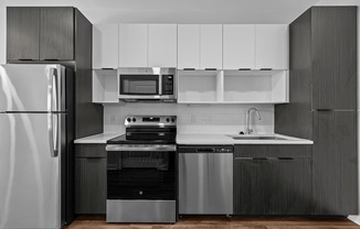 A modern kitchen with a refrigerator, oven, microwave, and sink.