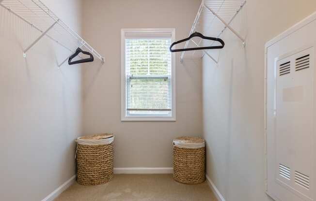 a walk in closet with two baskets and a window