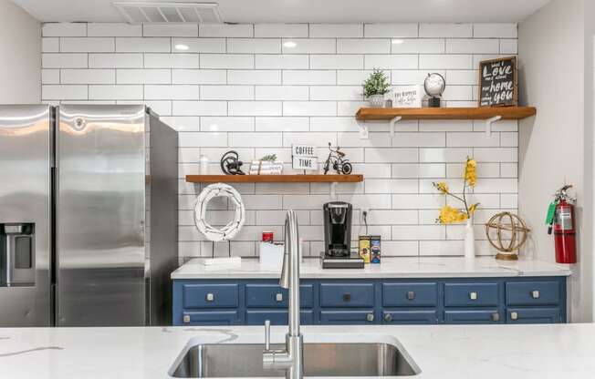 a kitchen with white countertops and blue cabinets