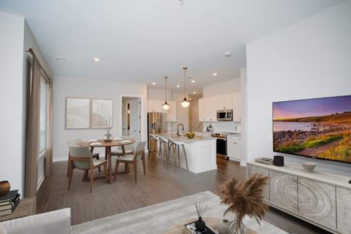 an open living room and kitchen area with a dining table and chairs and a flat screen tv at Fairfax, Grandview, OH, 43212