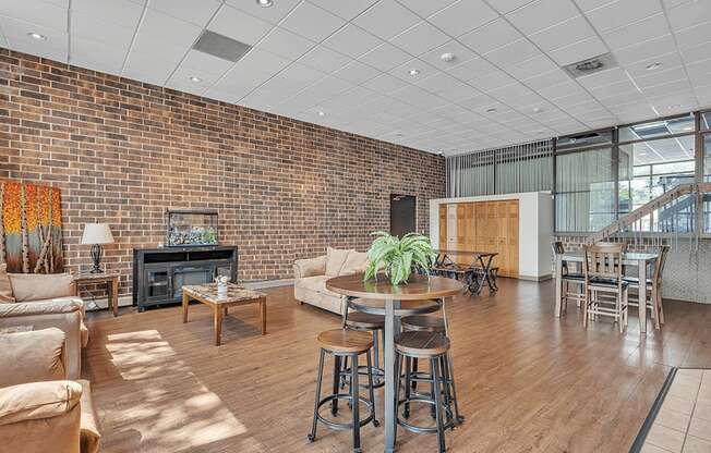 a living room with a couch and a table in front of a brick wall