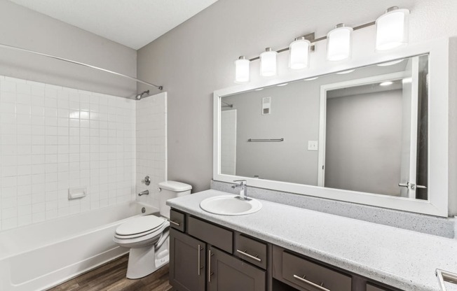 a bathroom with a large mirror and a toilet and sink