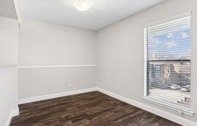 A room with a window and wooden flooring.
