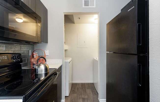 a kitchen with stainless steel appliances and a black refrigerator