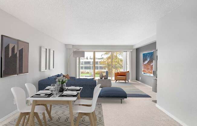 A dining room with a table set for two and a couch.