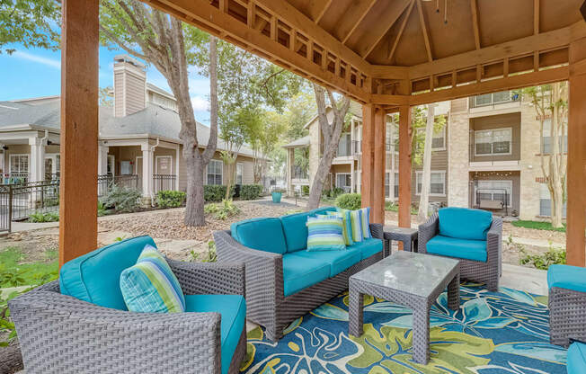a covered patio with couches and chairs and a table